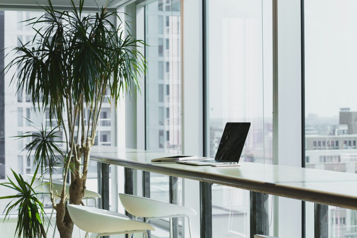 A bright office workspace with a laptop by the window